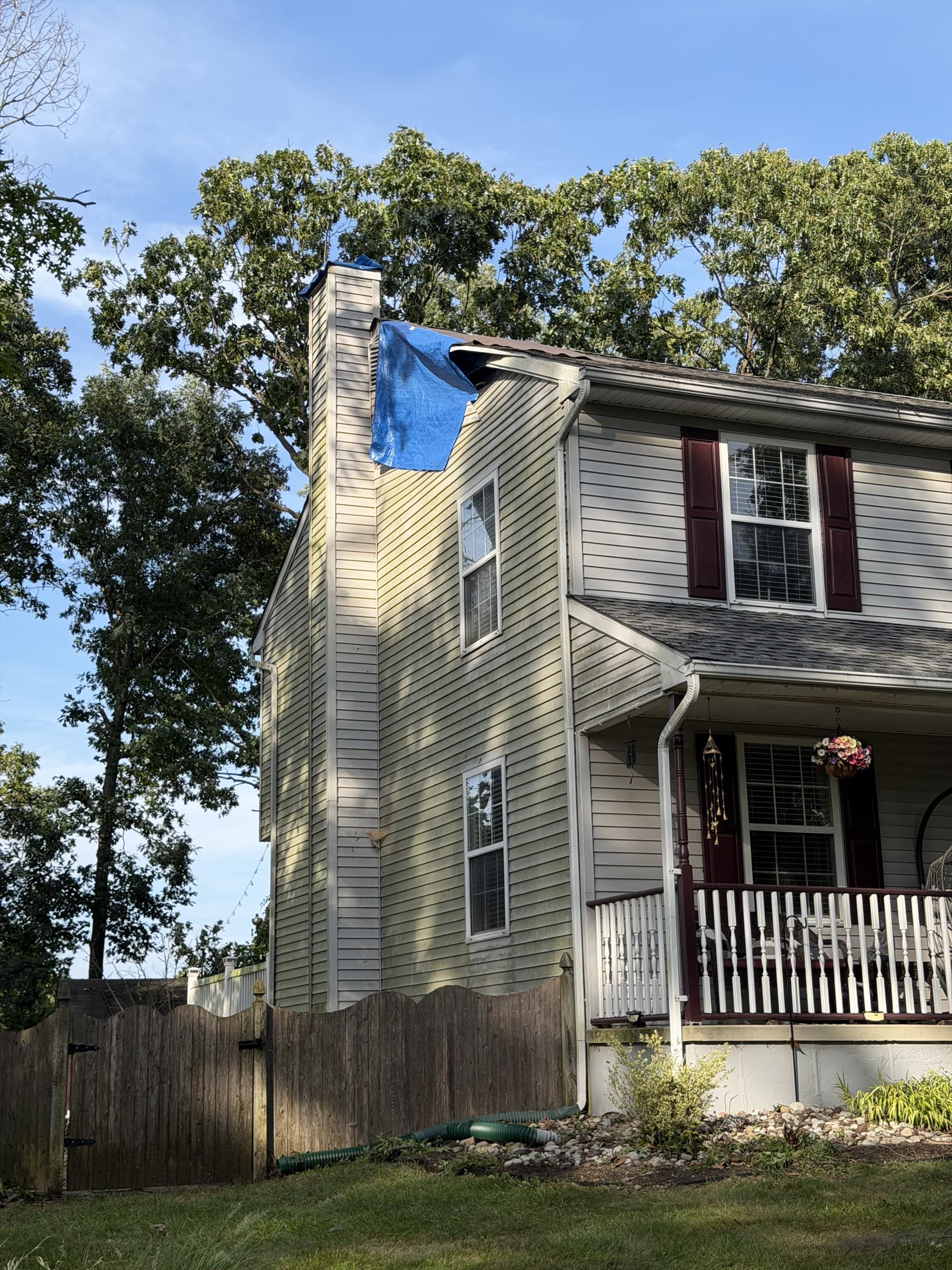 Blue tarp covering the storm-damaged roof after emergency tree removal in Mantua Township